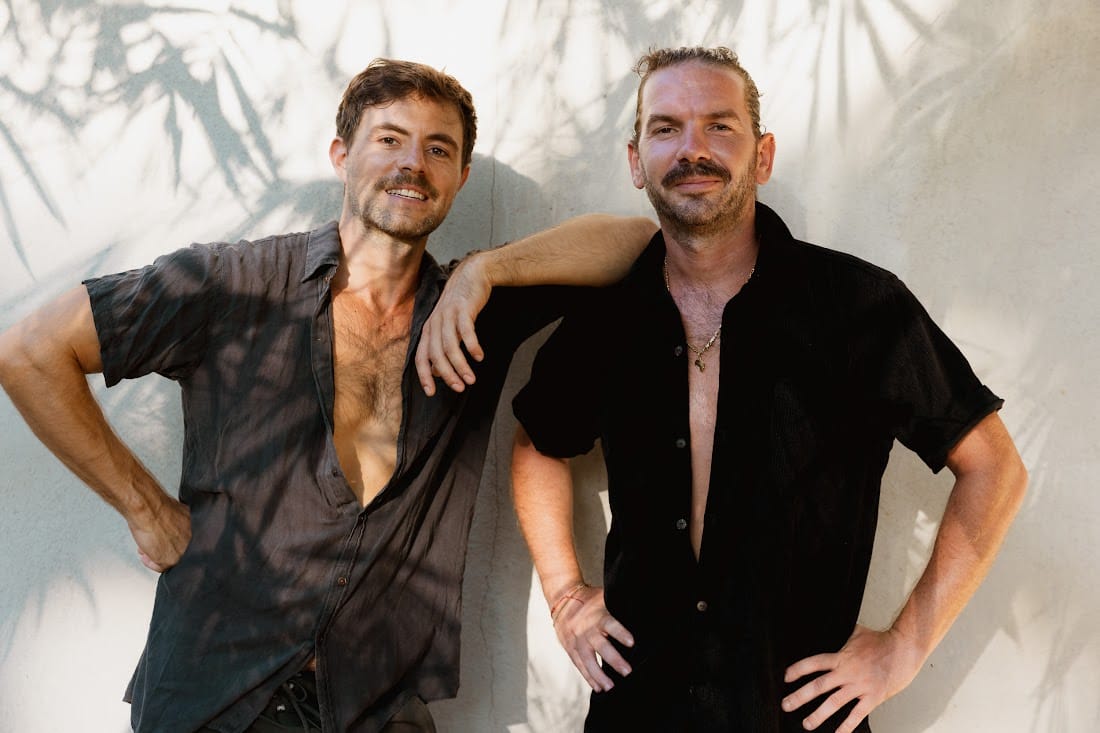 The two Kelani founders, arm in arm against a sunlit wall
