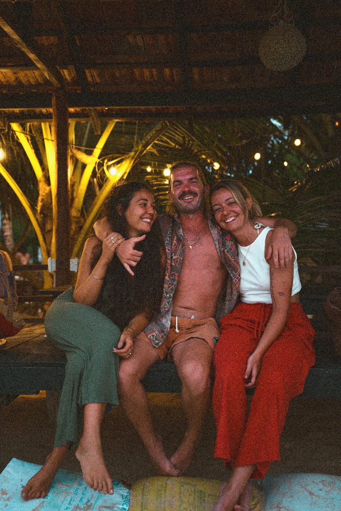 Friends laughing together at a beach bar after dark in Madiha
