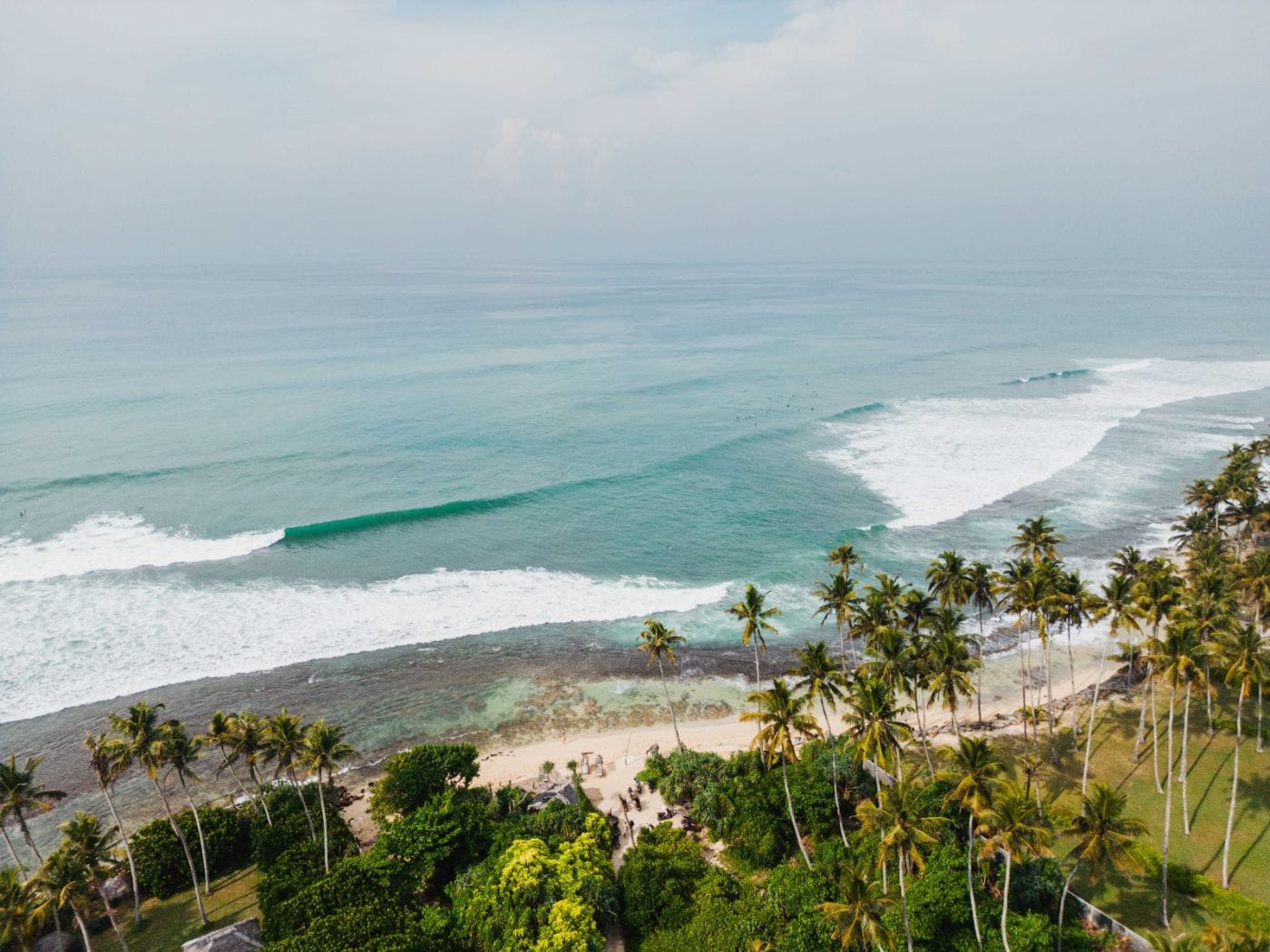 Aerial view of the reef break and palm-lined coast at Madiha