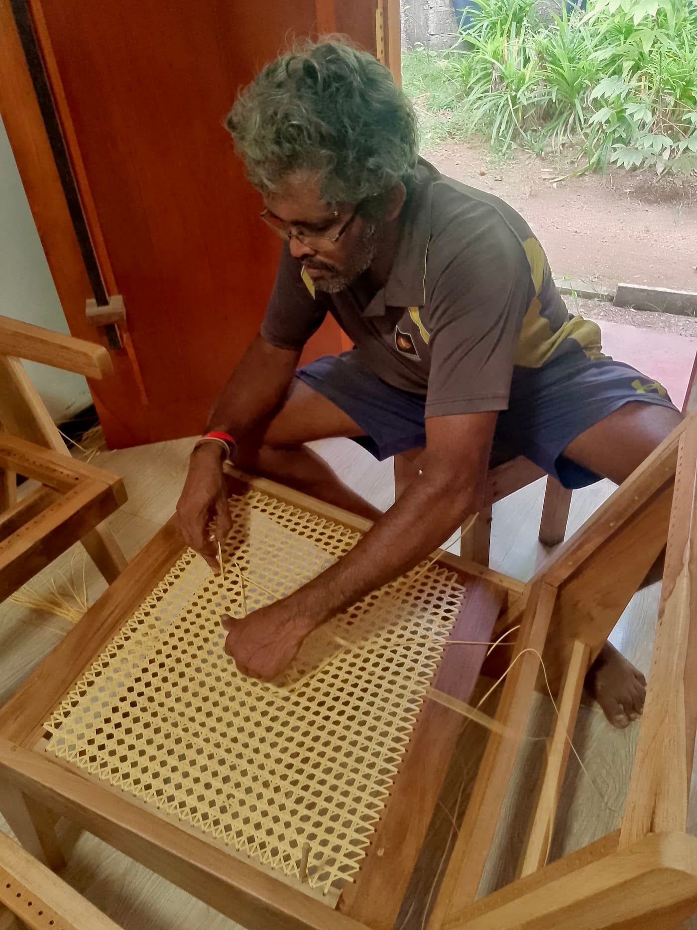 Our neighbour, a local carpenter in Madiha, weaving a rattan chair seat by hand